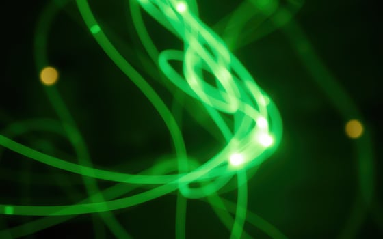 Colorful abstract light trails swirl and dance against a dark background photo