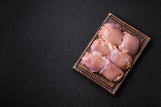 Fresh raw chicken thigh fillets with salt, spices and herbs photo