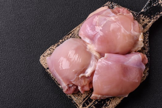 Fresh raw chicken thigh fillets with salt, spices and herbs photo