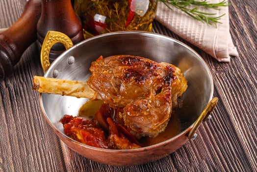 Baked lamb shank with vegetables photo