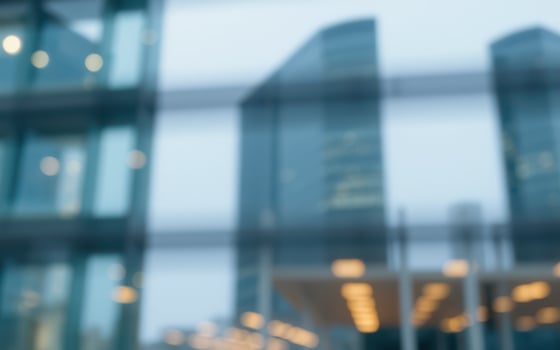 Modern skyscrapers blurred by glass in a bustling urban environment during early evening hours photo