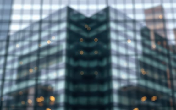 Urban reflection of modern skyscraper on glass surface showing artistic geometric patterns in cityscape photo
