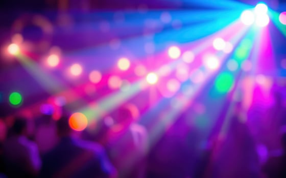 Colorful light beams illuminate a lively dance floor during a vibrant night party in a downtown venue photo