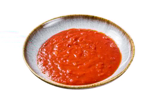 Homemade tomato Passata in rustic plate with herbs. Isolated on white background. Top view. photo