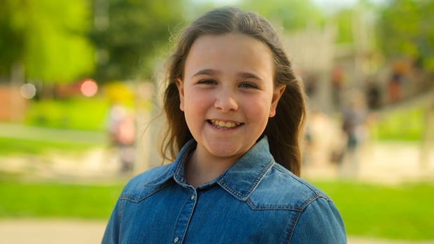Portrait little kid Caucasian child happy positive emotion pretty schoolgirl teen pupil daughter adoption custody childcare medical insurance smile toothy girl joyful innocence face outdoors city park photo