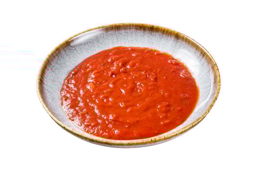 Homemade tomato Passata in rustic plate with herbs. Isolated, white background. photo