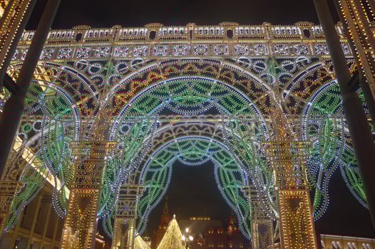 Christmas street arch, equipped with many yellow and turquoise lights. Festive New Year's element of city street decor in the evening. Russia, Moscow. photo