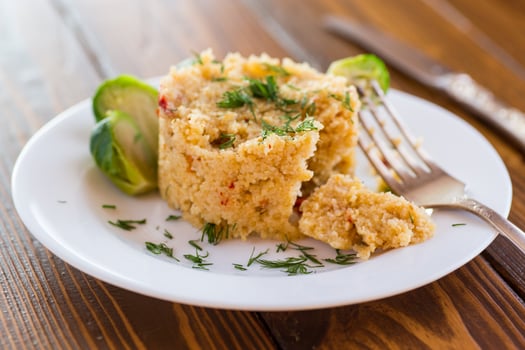 homemade cooked bulgur with Brussel sprouts in a plate, on a wooden table photo