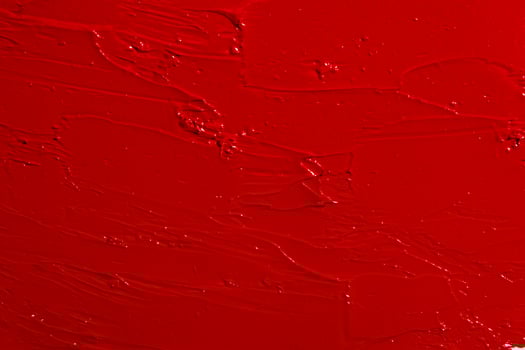 Texture of red lipstick covering the entire image. Bold cosmetic background, rich color. photo