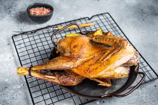 Baked Guineafowl, guinea fowl with potato in steel tray. Gray background. Top view photo