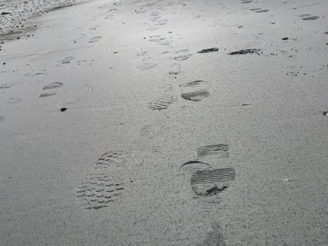 Foot prints on sea side beach background photo