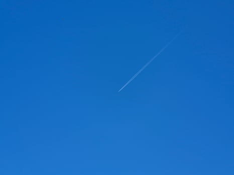 White airplane trail in the summer sky background photo