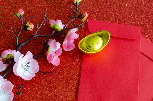 Top view of pink flower, golden ingot and Chinese New Year red packet photo