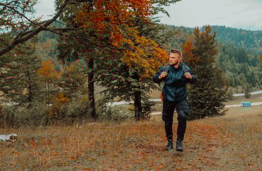 A male traveler hiking in the mountain forest. photo