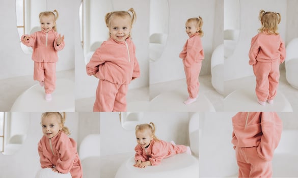 Smiling toddler girl wearing pink tracksuit posing in studio photo