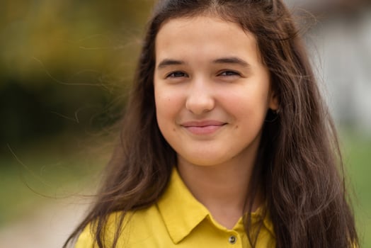 Close up portrait of a happy charming teenage girl with dimples on her cheeks looking at camera and smiling. photo
