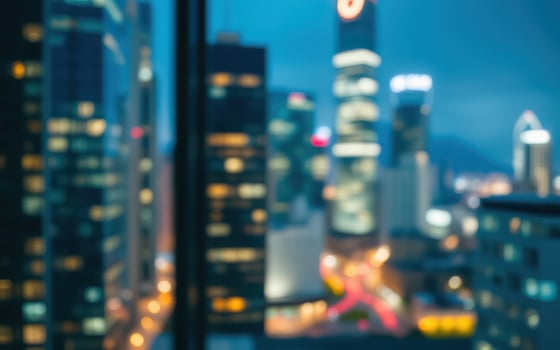 City skyline illuminated by evening lights captured from a high-rise building window photo