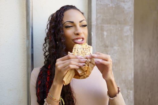 A woman is enjoying a truly delicious and tasty snack while being outdoors in the fresh air photo