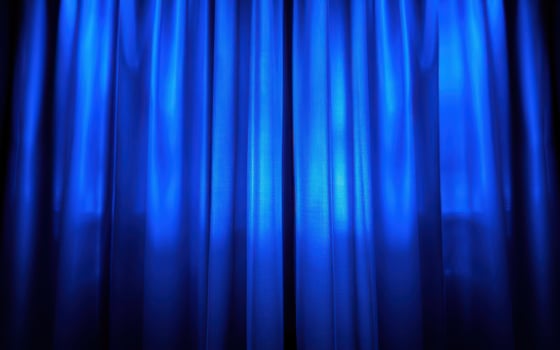 Beautiful blue curtains elegantly flowing in soft light at a theater venue during a performance photo