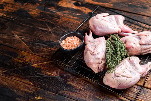 Farm eco friendly raw quails on kitchen table. Wooden background. Top view. Copy space photo
