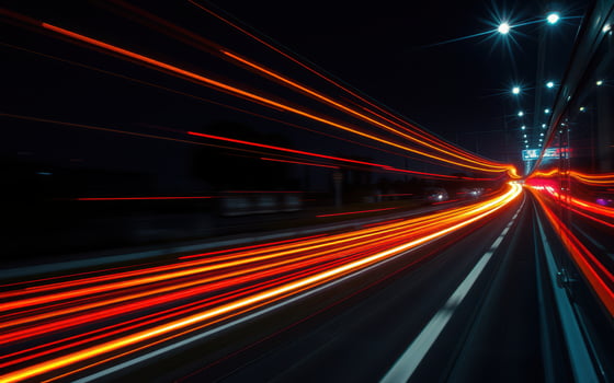 Nighttime cityscape with streaks of light from moving vehicles on a busy road photo