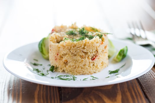 homemade cooked bulgur with Brussel sprouts in a plate, on a wooden table photo