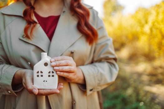 Woman holding white house model in hand.Mortgage loan approval home loan and insurance concept. photo