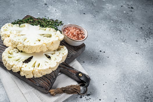 Cooking of cauliflower steak, Vegetarian cuisine. Gray background. Top view. Copy space photo