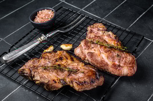 BBQ Grilled Pork loin steaks, neck meat. Black background. Top view photo