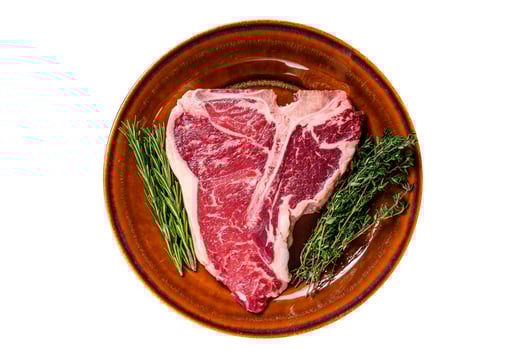 Raw porterhouse beef meat Steak with herbs on a plate. Isolated on white background. photo