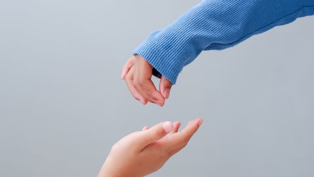 two young girl hands reaches out to help or give, try to touch. photo
