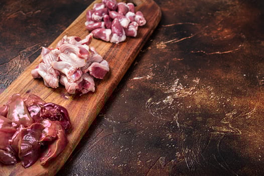 Raw chicken offals, liver, hearts, gizzards Stomach meat set. Dark background. Top view. Copy space photo
