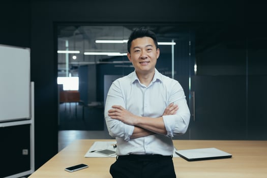Portrait of successful asian boss in modern office, man standing with crossed arms smiling and looking at camera, portrait of successful businessman investor photo