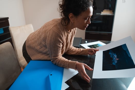 Woman reviewing photography prints in a modern home office setting photo