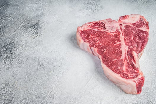 Porterhouse T-bone raw beef meat Steak. White background. Top view. Copy space photo