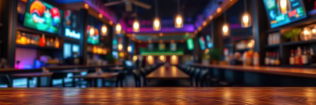 Modern bar interior with vibrant lighting and multiple screens showcasing sports events during evening hours photo