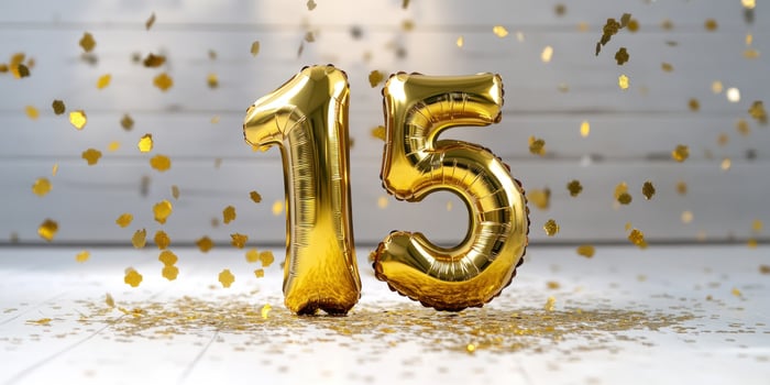 Celebratory reflective golden 15 balloon amidst confetti for milestone anniversary or birthday photo