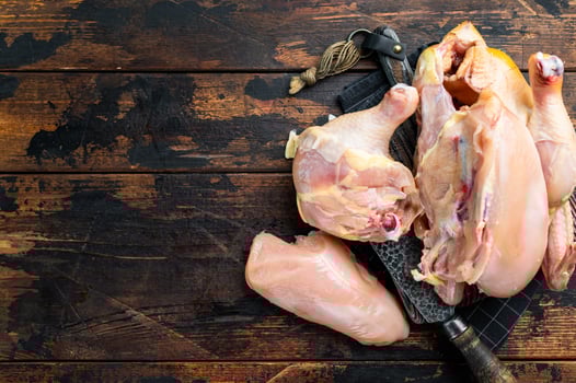 Raw chicken pieces on a wooden table, ready for cooking photo