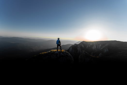 A person who hikers enjoys a break look at the top of the mountain, adventure travel. photo