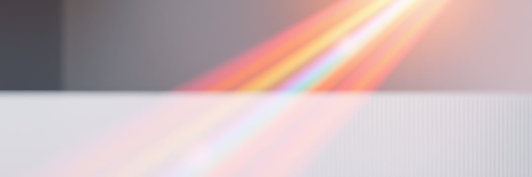 Colorful light refracts through a prism, creating a vibrant spectrum on a surface in a bright indoor setting photo