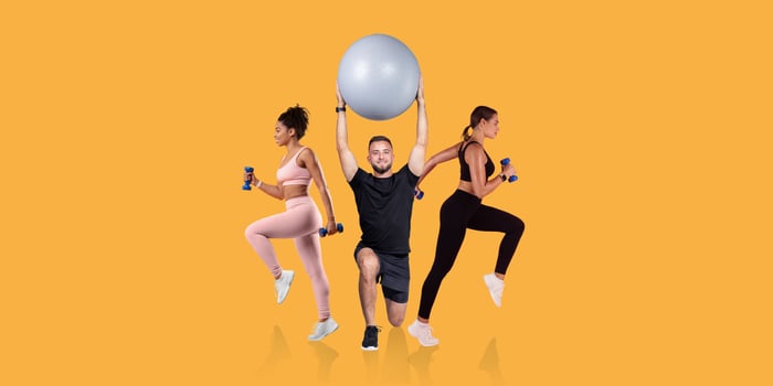 Three individuals are engaging in a fitness routine, using dumbbells and a stability ball. The setting features a vibrant yellow backdrop, enhancing the energetic atmosphere of the activity. photo
