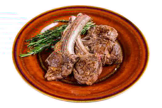 BBQ grilled lamb mutton meat chops steaks on a plate. Isolated on white background. photo