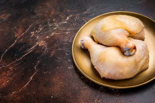Chicken legs, raw poultry meat on black background, top view photo