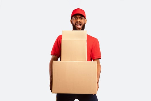 Delivery Service. Overworked Courier Man Holding Cardboard Boxes Delivering Goods Standing On Yellow Background. Studio Shot photo
