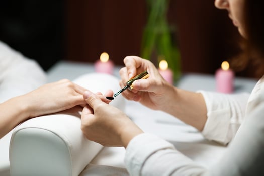 In a relaxing salon setting, a woman enjoys a manicure treatment while having her nails pampered. Soft candlelight creates a serene atmosphere for beauty care. photo