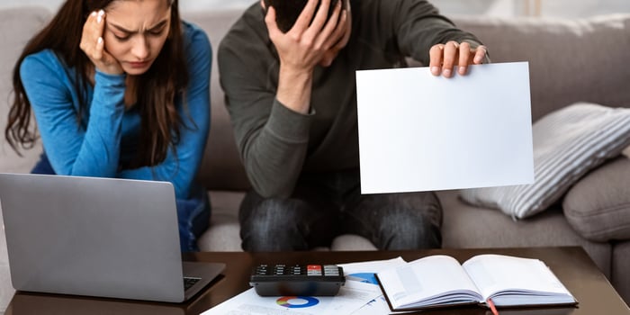 Unhappy couple calculating domestic budget in living room, trying to save money, looking stressed and frustrated photo