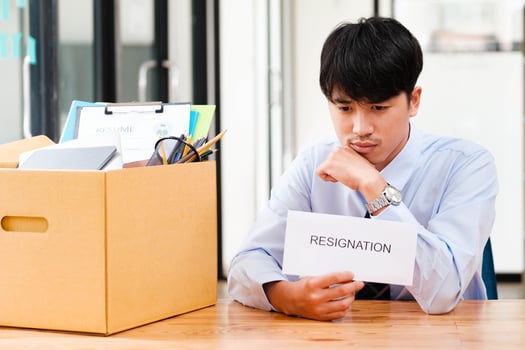 Disappointed Businessman Holding Resignation Letter and Packing Belongings. photo