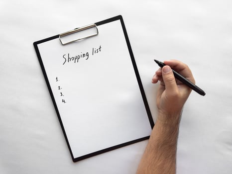 Handwriting a minimalist shopping list on clipboard photo
