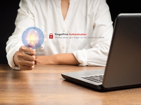 Businesswoman login by fingerprint while sitting in the office. Technology fingerprint scan provides security photo