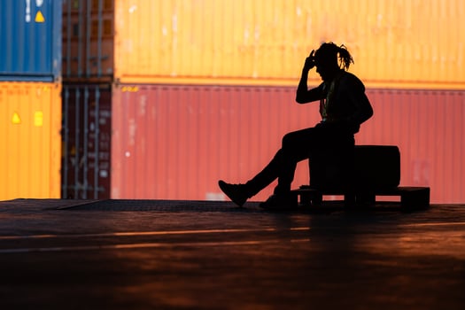 Warehouse worker's headache from hard work while sitting and relaxing, Silhouette concept photo